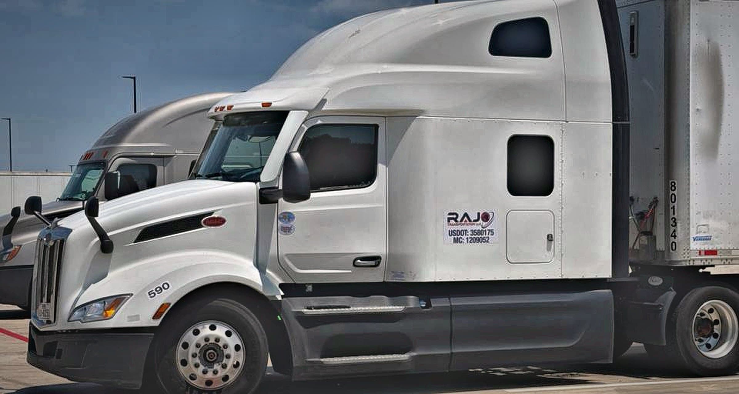 RAJO Transportation tractor staged in the yard beside a customer trailer